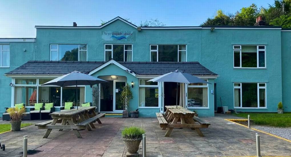 The exterior of the large White Horse House, offering spacious hen weekend accommodation in Herefordshire that sleeps 30, with an outdoor patio area.