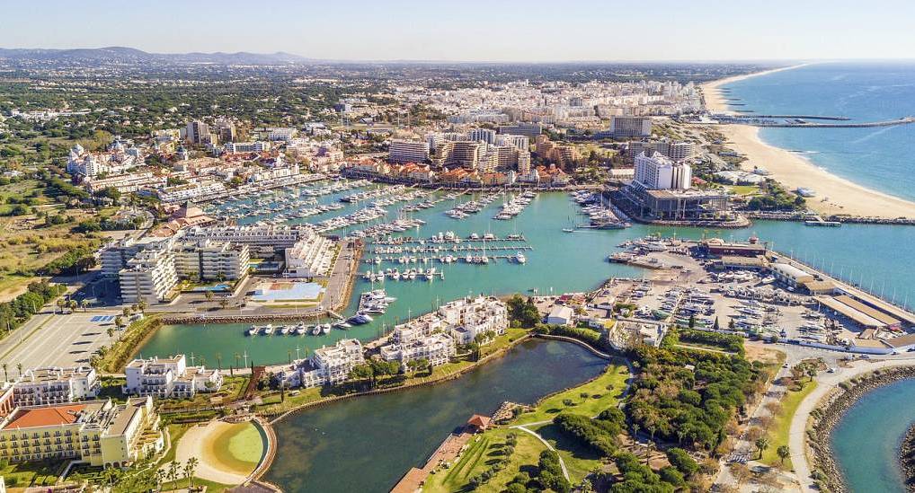 Aerial view of Vilamoura Marina with yachts and sandy Algarve beaches, sunny coastal backdrop for a Vilamoura hen do.