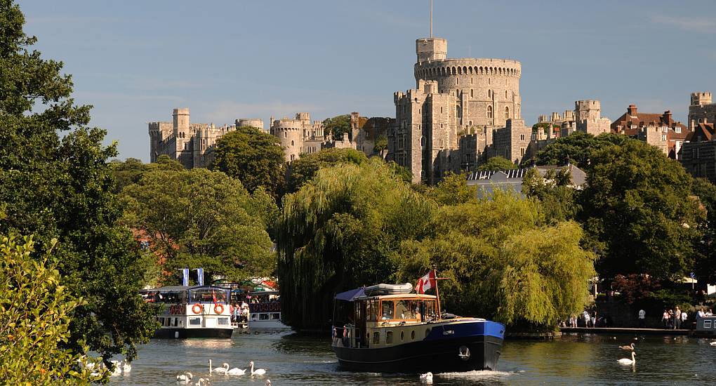 Passenger boat cruising on the River Thames with Windsor Castle in the background, scenic backdrop for a Windsor stag do.