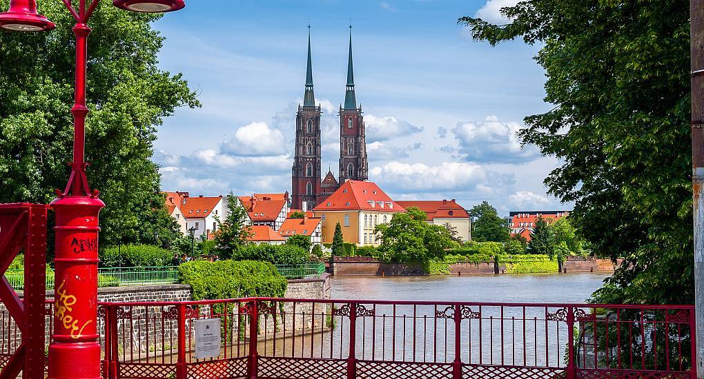 Red Tumski Bridge overlooking Odra River and Wrocław Cathedral spires, scenic Ostrów Tumski backdrop for a Wrocław stag do.