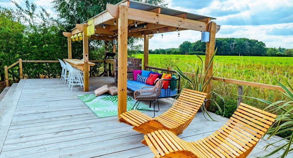 The wooden sun deck and outdoor bar at Sunset Serenade, a stylish private hen villa near York sleeping large groups.