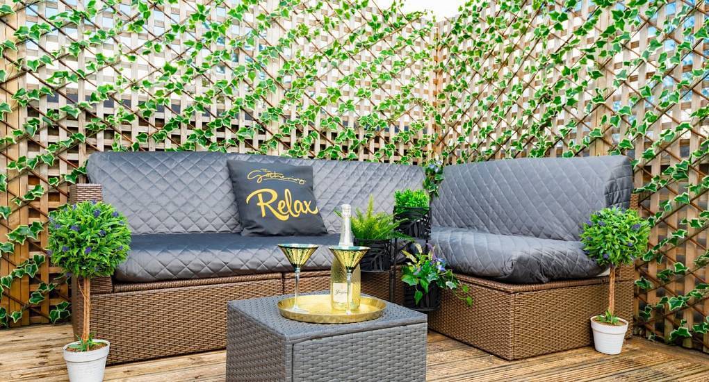 The ivy trellis outdoor patio seating area at The Glider, coach house hen accommodation with city wall views.