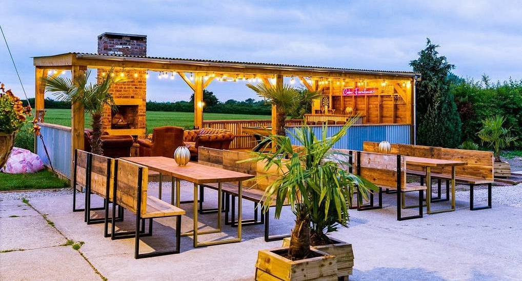 The covered pergola outdoor bar and bench dining area at The Grange, a rural York hen party house with hot tub.
