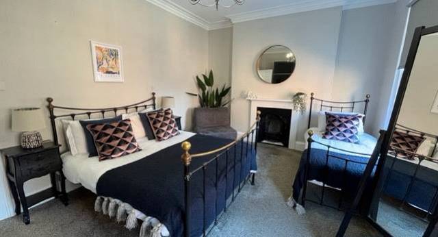 The elegant bedroom with wrought iron double bed at The Victorian, a central York hen party house for 16.