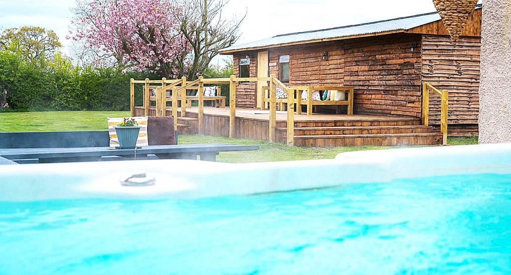 The outdoor hot tub and timber party lodge deck at Yorkshire Treat, a rural York hen party complex sleeping 20.